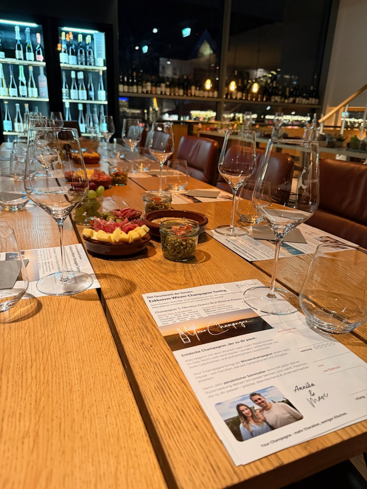 Gedeckte Tafel mit Winzerchampagner, Snacks und Riedel-Gläsern am Abend